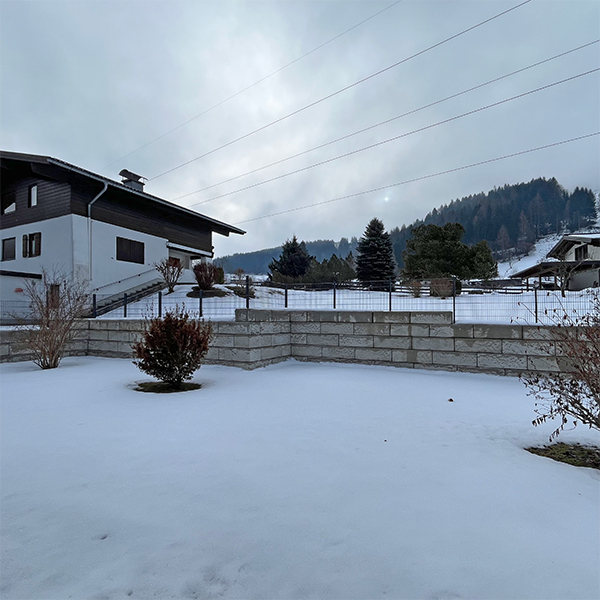 Stützmauer mit integriertem Zaun als Gartenabgrenzung